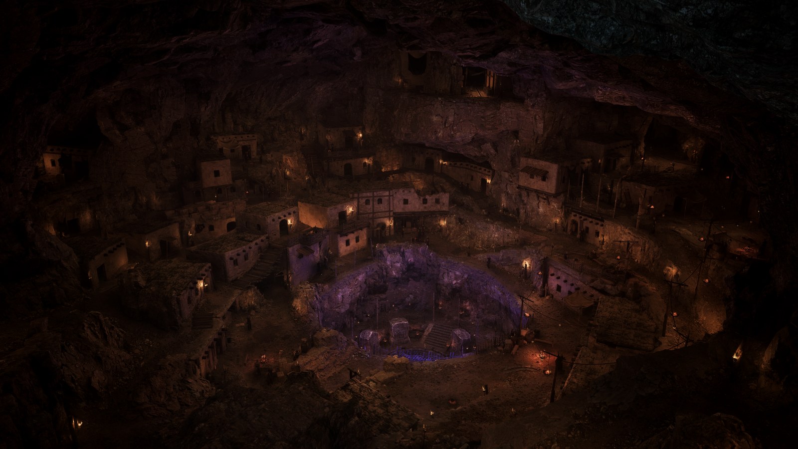 An underground settlement in Gothic 1 Remake: rows of small flat-roofed stone houses lit by torches, built into the terraced walls of a vast dark cavern around a deep central pit that glows purple and blue